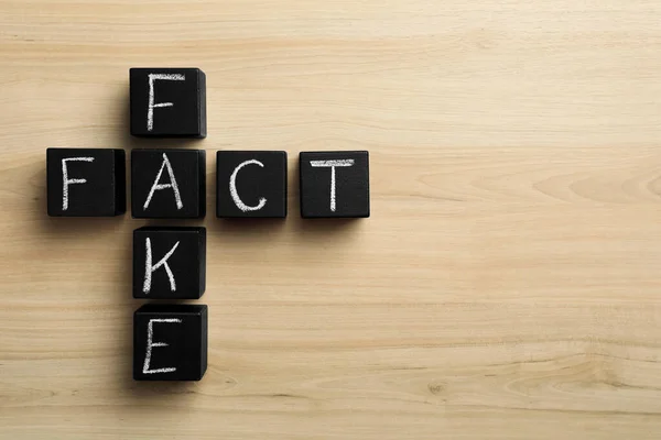 Words Fake Fact Made Black Cubes Wooden Table Flat Lay — Fotografia de Stock