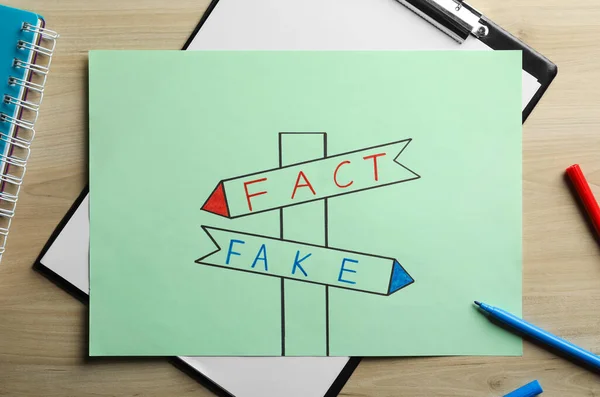 Drawn Signpost Words Fact Fake Paper Sheet Wooden Table Flat — Fotografia de Stock