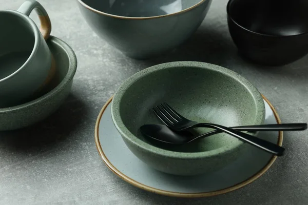 Açık gri masadaki boş bulaşık takımı ve çatal bıçak takımı, yakın plan.
