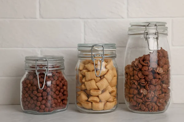 Glazen Containers Met Verschillende Ontbijtgranen Witte Aanrecht Buurt Van Bakstenen — Stockfoto