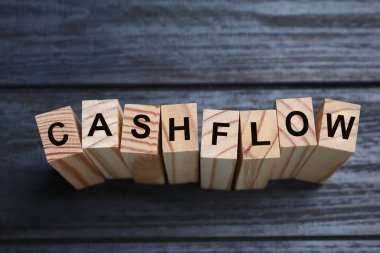 Siyah ahşap zemin üzerinde Cash Flow ifadesi olan bloklar, üst görünüm