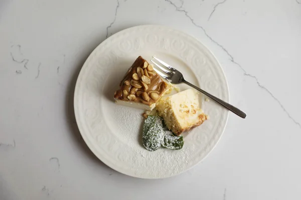 Tasty dessert and fork on white marble table, top view