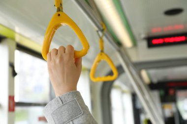 Toplu taşımada el ele tutuşan kadın, yakın plan.