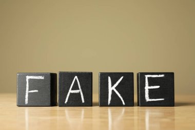 Tahta masada siyah küplerle yapılmış bir kelime, yakın plan.