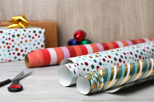 Different Colorful Wrapping Paper Rolls Scissors White Wooden Table Closeup — Zdjęcie stockowe