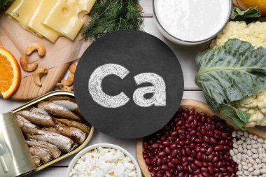 Beyaz ahşap masada yüksek kalsiyum içeren doğal besin seti.