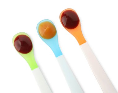 Beyaz arka planda kaşıklarda sağlıklı bebek mamaları, üst manzara