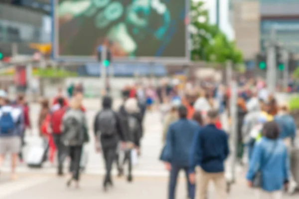 People crossing street in city, blurred view