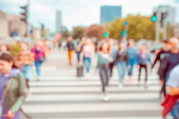 People crossing street in city, blurred view