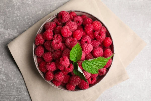 Bowl Fresh Ripe Raspberries Green Leaves Grey Table Top View — Fotografia de Stock