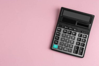 Pembe arka planda modern hesap makinesi, üst görünüm. Metin için boşluk