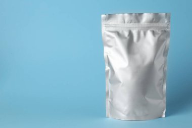 Açık mavi arkaplanda boş bir folyo paketi. Metin için boşluk