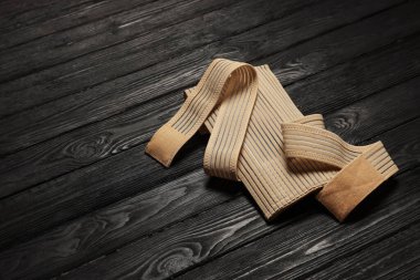 Beige posture corrector on black wooden table, space for text
