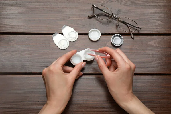 Woman Taking Contact Lens Case Tweezers Wooden Table Top View — Stockfoto