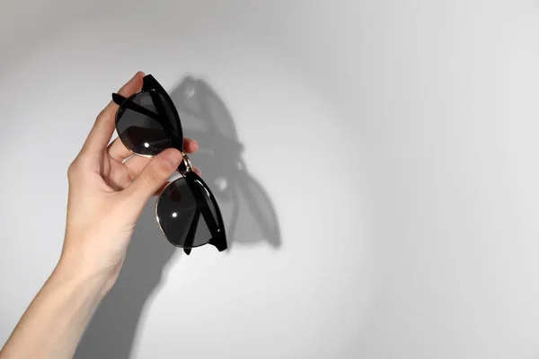 Woman Holding Stylish Sunglasses Light Background Closeup Space Text — Φωτογραφία Αρχείου