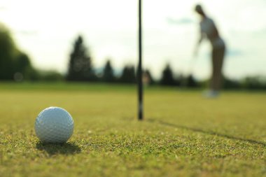 Yeşil sahada golf oynayan kadın, topa odaklan. Metin için boşluk