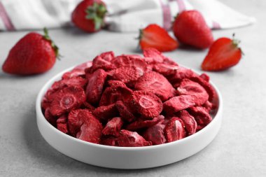 Açık gri masada dondurulmuş taze çilekler, yakın plan.