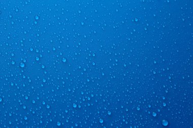 Su damlaları mavi arkaplanda, üst görünümde