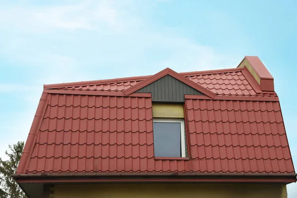 Mavi gökyüzüne karşı kırmızı çatılı güzel bir ev