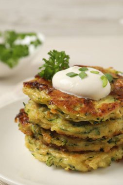 Lezzetli kabaklı börek, tabakta ekşi krema, yakın plan.