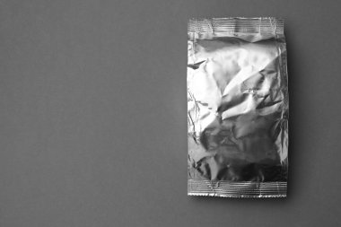Blank foil package on grey background, top view. Space for text