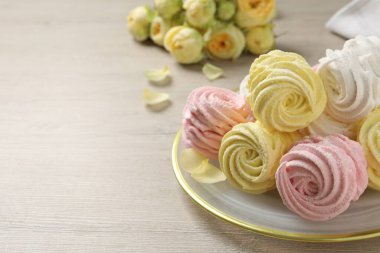 Delicious marshmallows on white wooden table. Space for text