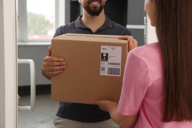 Kadın kuryeden paket alıyor, yakın plan.