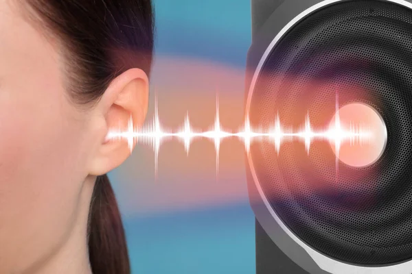 Modern audio speaker and woman listening to music on light blue background, closeup view of ear