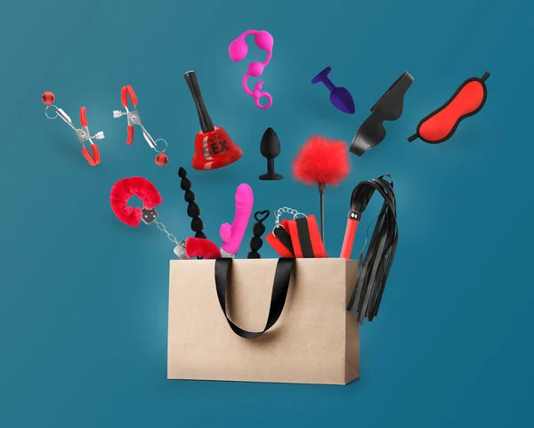 Different Sex Toys Accessories Falling Paper Shopping Bag Blue Background — Φωτογραφία Αρχείου