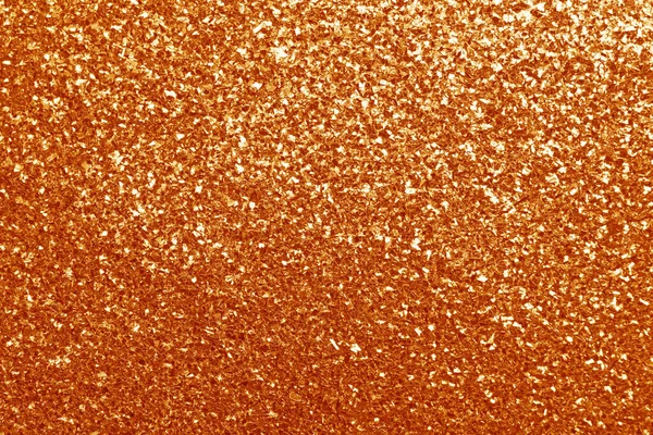 Beautiful shiny orange glitter as background, closeup