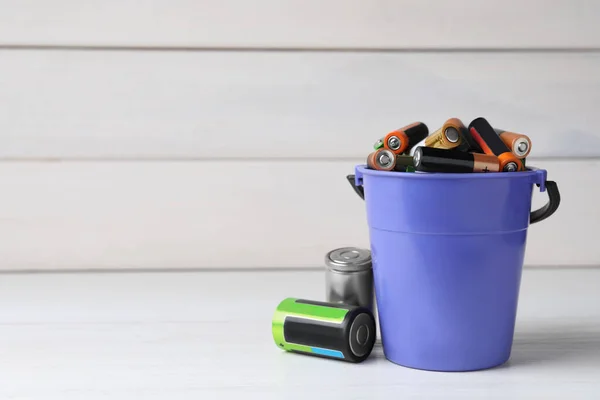 Many Different Used Electric Batteries Bucket White Wooden Table Space — Stockfoto