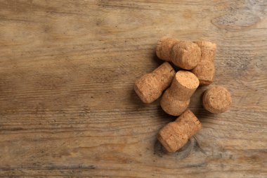 Sparkling wine corks on wooden table, flat lay. Space for text