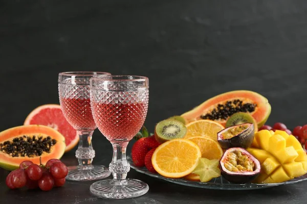 Νόστιμα Εξωτικά Φρούτα Και Ποτήρια Κρασί Μαύρο Τραπέζι — Φωτογραφία Αρχείου