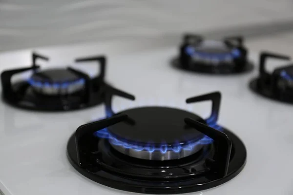 Modern kitchen stove with burning gas, closeup