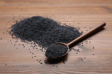 Black sesame and spoon on wooden table