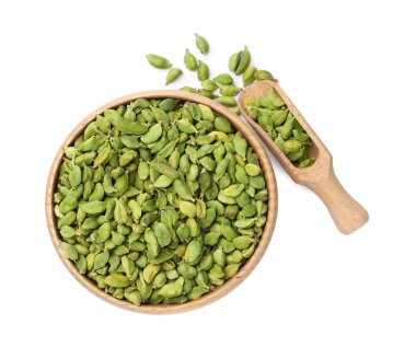 Wooden bowl and scoop with dry cardamom seeds on white background, top view