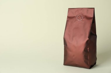 One blank foil package on beige background. Space for text