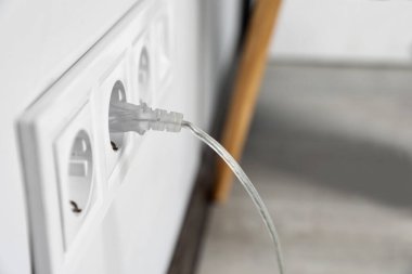 Power socket and plug on wall indoors, closeup