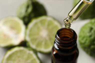 Bergamot yağı masaya dökülüyor, cam şişeye, yakın plan.