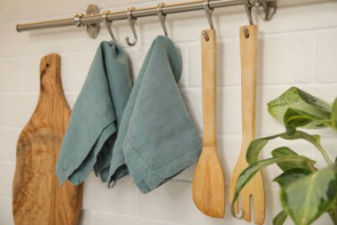 Clean towels and utensils hanging on rack in kitchen