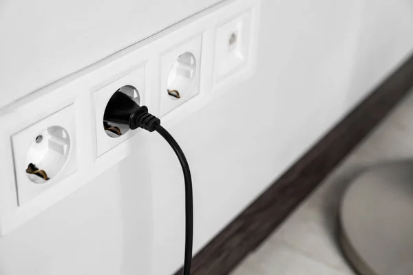 Power socket and plug on wall indoors, closeup. Space for text