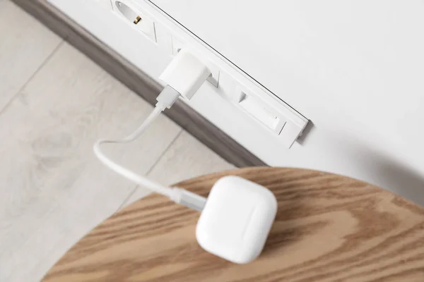 Modern Wireless Earphones Charging Electric Socket Indoors View — Stockfoto