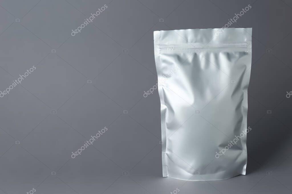 One blank foil package on grey background. Space for text