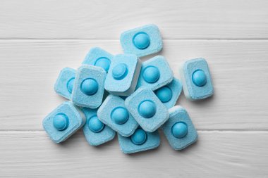 Water softener tablets on white wooden table, flat lay