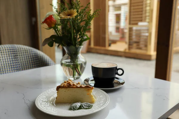 Tasty dessert and cup of fresh coffee on table in cafeteria