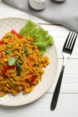 Beyaz ahşap masada sebzeli leziz pirinç pilavı.