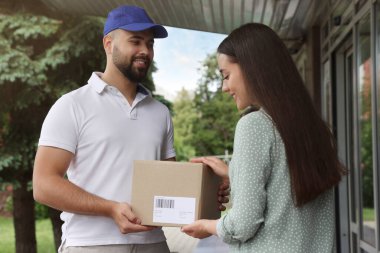 Dışarıdaki kuryeden paket alan kadın. Teslimat servisi