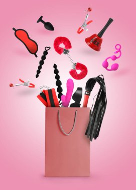 DIfferent sex toys and accessories falling into paper shopping bag on pink background