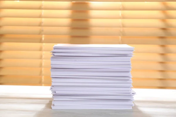 Stack of paper sheets on white wooden table