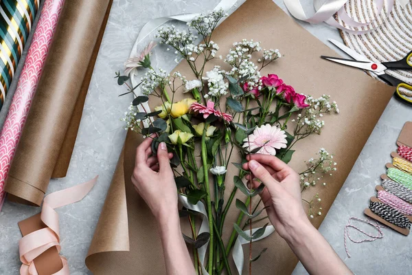 Woman Arranging Flowers Grey Stone Table Top View — Fotografia de Stock